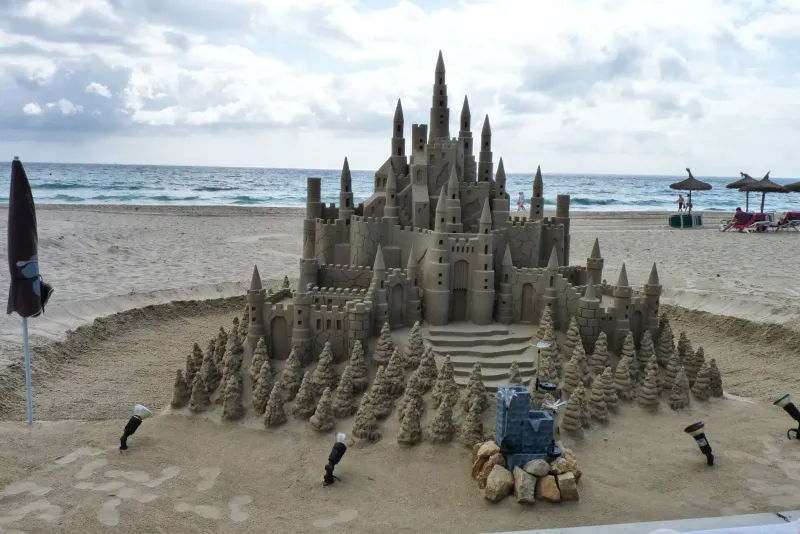 Große Sandburg mit vielen Türmen am Strand